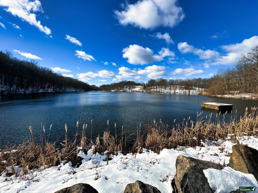 A lake with snow and rocks.